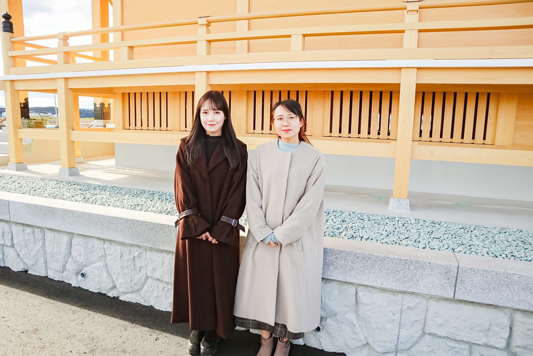 再建中の苕野神社をバックに並ぶ諸橋沙夏さんと横山和佳奈さん