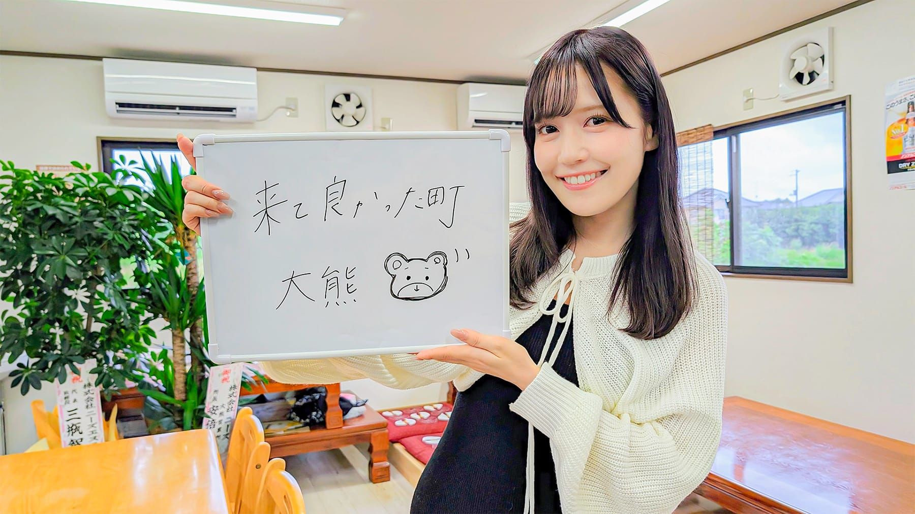 「来て良かった町大熊」と書かれたホワイトボードを掲げる女性アイドルグループ「=LOVE」のメンバー諸橋沙夏さんの写真